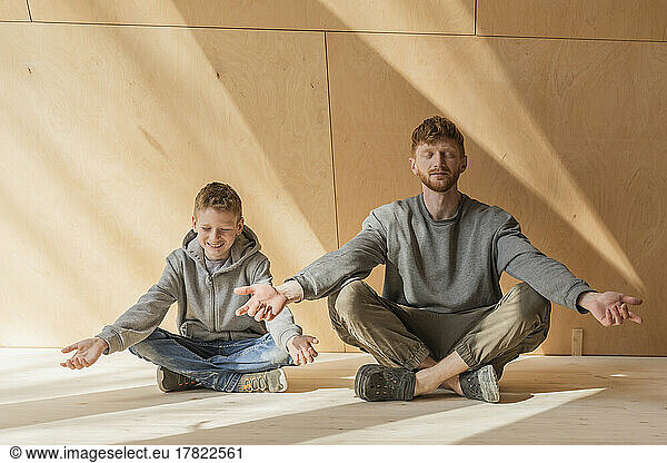 Father and son meditating at the sustainable eco house