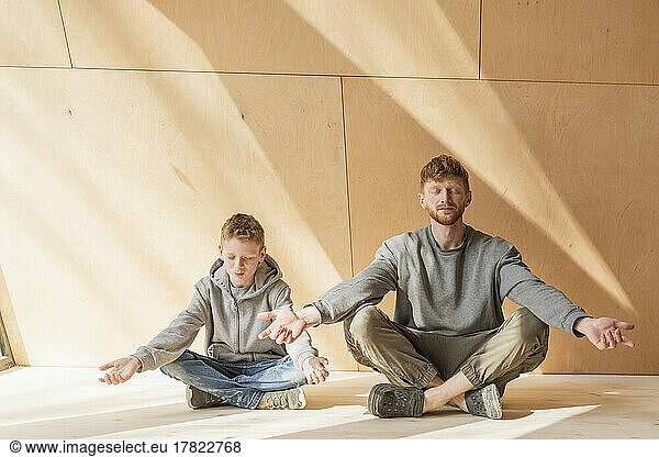 Father and son meditating at the sustainable eco house
