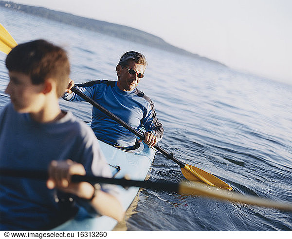 Father and son paddling sea kayak