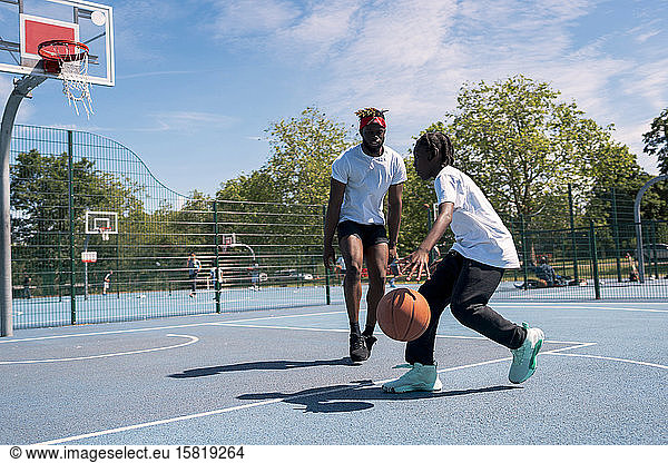 Father and son playing basketball on basketball court