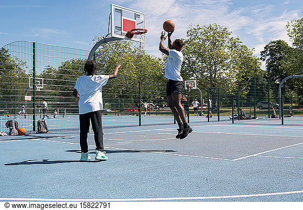 Father and son playing basketball on basketball court