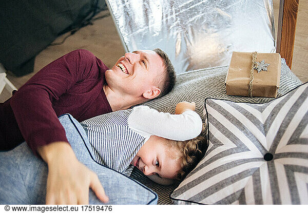 Father and son playing pillow fight on the bed