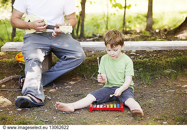 Father and son playing with musical toy instruments at playground