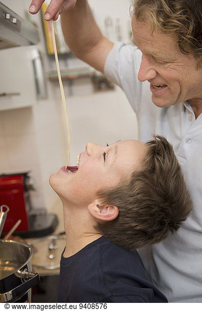 Father and son tasting spaghetti