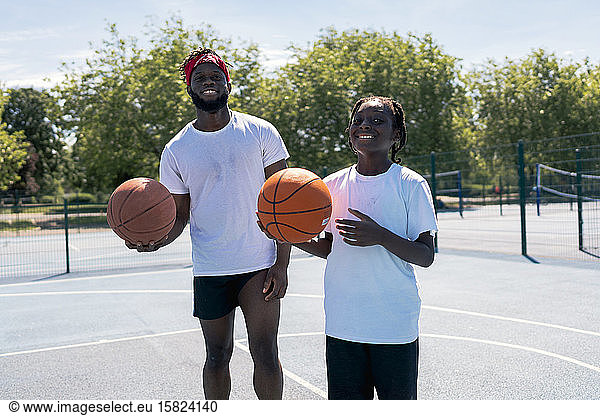 Father and son with basketball on basketball court