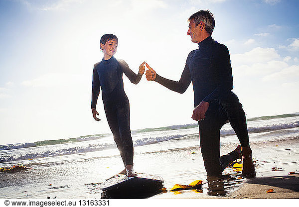 Father and son with surfboard on beach  Encinitas  California  USA