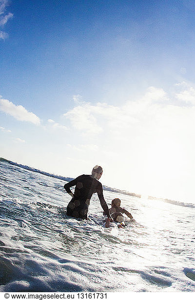 Father and son with surfboard on sea  Encinitas  California  USA