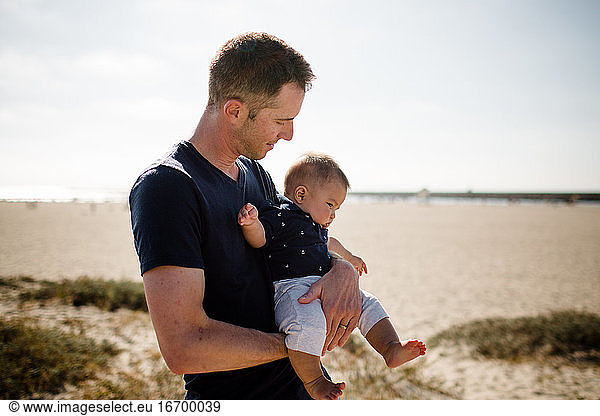 Father Cradling Infant Son on Beach