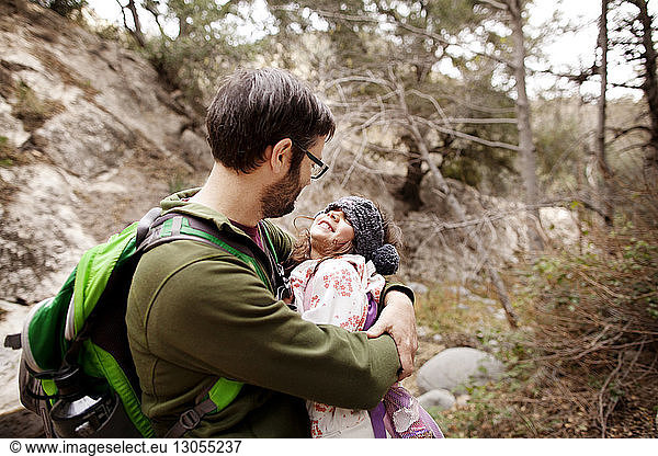 Father embracing girl in forest
