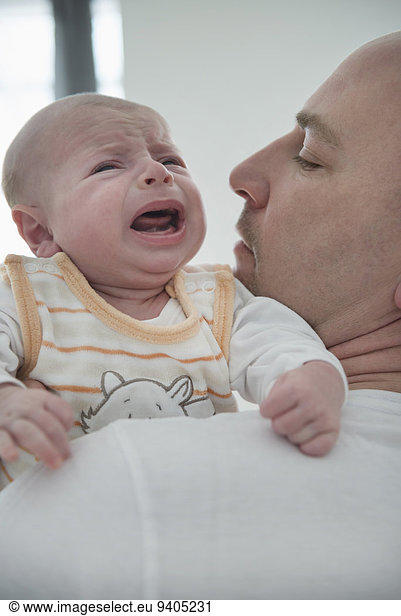 Father holding his crying son  close up
