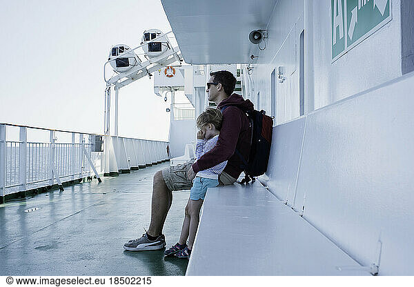 father hugging daughter on the deck of a ferry at sea