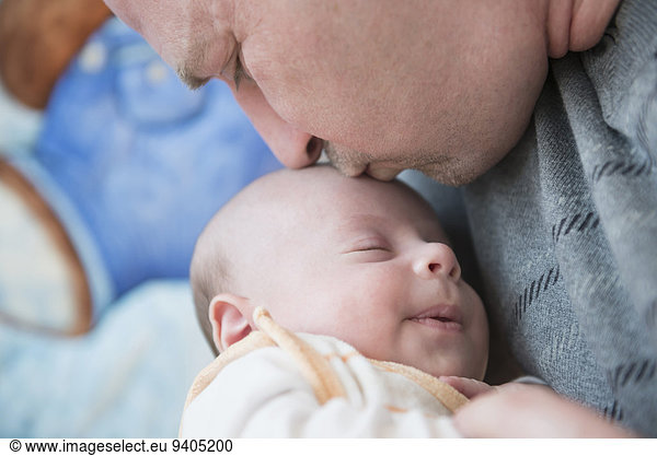 Father kissing his sleeping son  close up