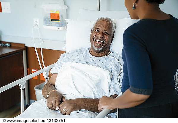 Father laughing while looking at daughter in hospital ward