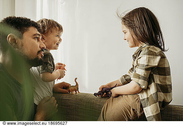 Father spending leisure time with sons playing at home