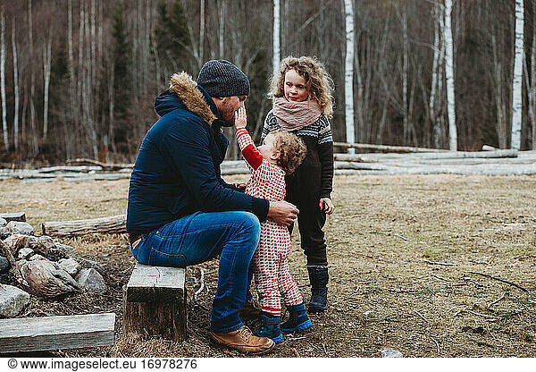 Father spending time outdoors with children in Scandinavian forest