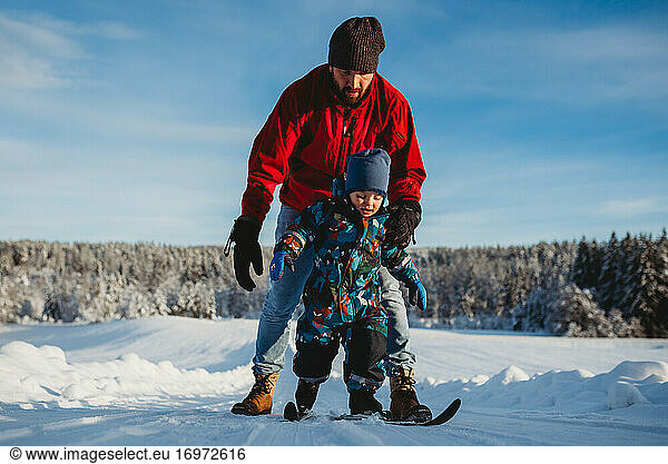 Father teaching son to cross country ski in winter wonderland Norway