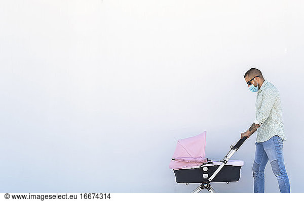 father walking with his baby's stroller