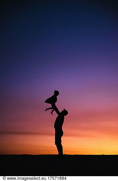 Father with baby during sunset.