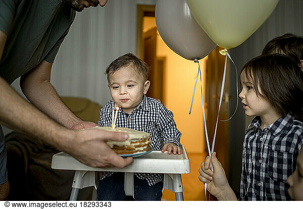 Father with birthday cake celebrating son's birthday at home