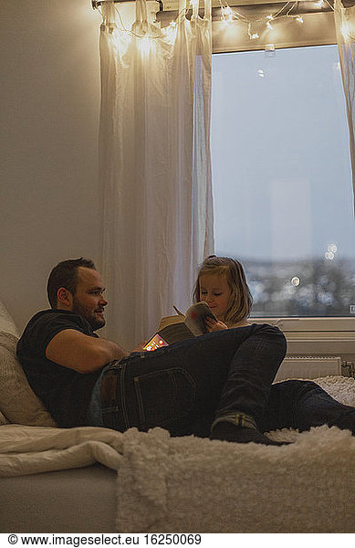Father with daughter on bed