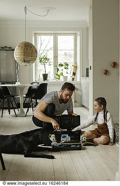 Father with daughter repairing skateboard