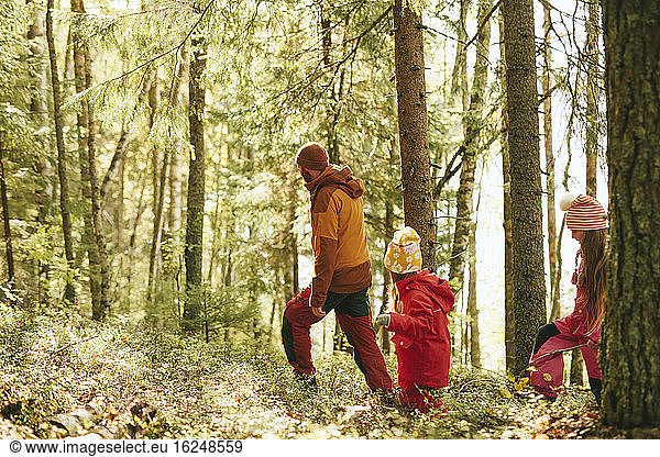Father with daughter walking through forest