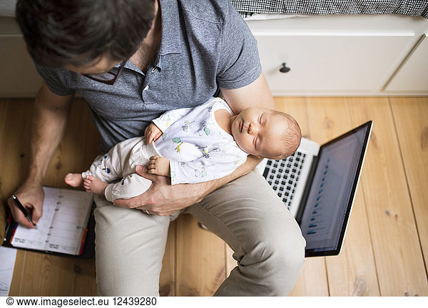 Father with his baby daughter working from home