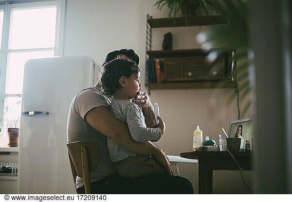Father with son taking online advice from female doctor at home during pandemic