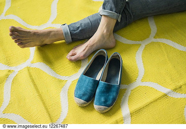 Feet and shoes of a woman  relaxing on a yellow rug