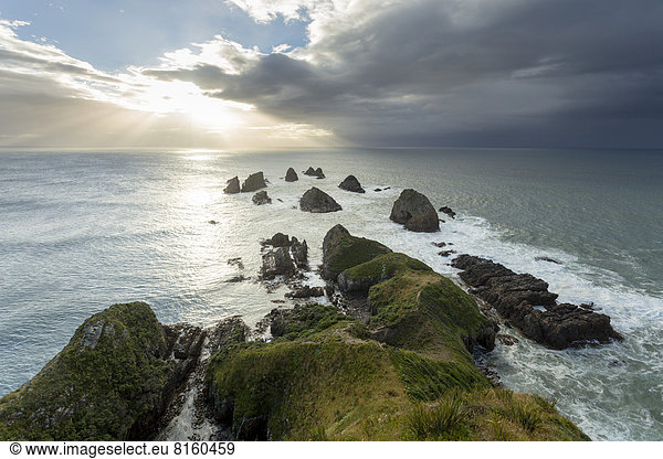 Felsen ragen aus dem Pazifik mit aufgehender Sonne am Nugget Point