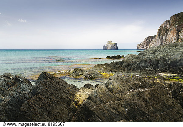 Felsformationen in der Bucht Spiaggia di Masua mit dem Fels Pan di Zucchero im Meer