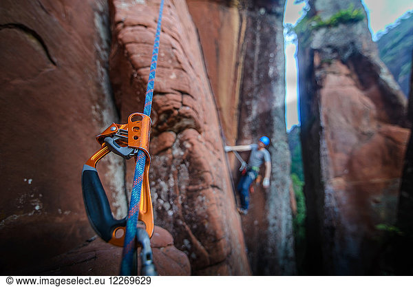 Felskletterer beim Klettern an Sandsteinfelsen  Schwerpunkt Ausrüstung im Vordergrund  Liming  Provinz Yunnan  China
