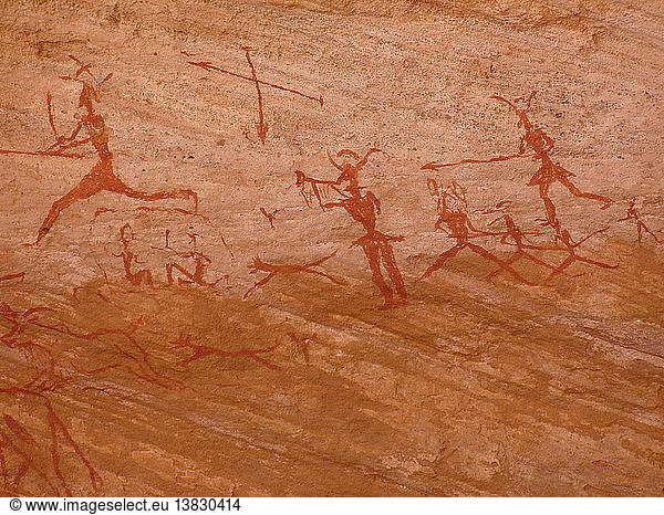 Felsmalerei  Darstellungen monochromer anthropomorpher Figuren waren in der Rundkopfzeit sehr verbreitet. Diese Szene könnte eine Darstellung einer groß angelegten Jagd sein. Libyen. ca. 6500 v. Chr.