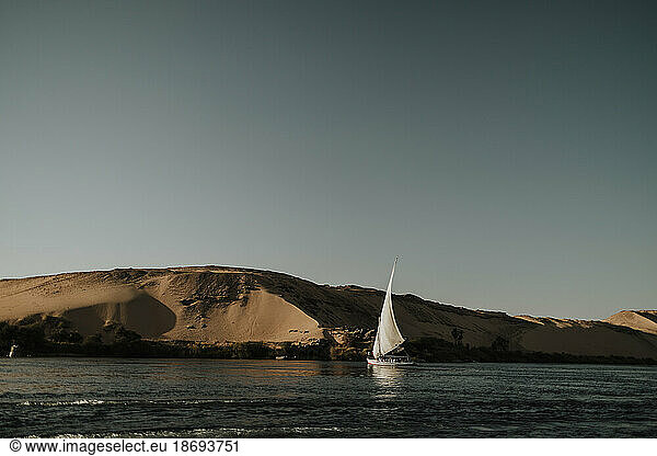 Felucca boat sailing on Nile river at sunset