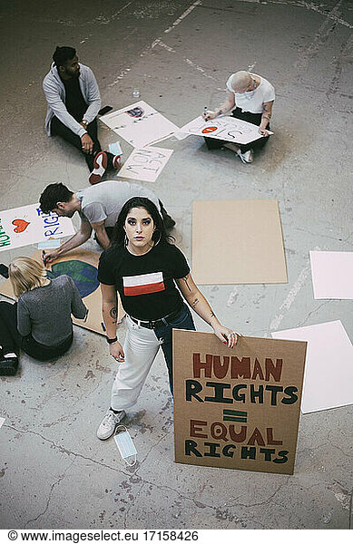 Female activist with equal rights signboard standing in building