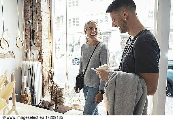 Female and male clients laughing while standing in design studio