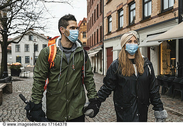 Female and male tourists exploring city during pandemic