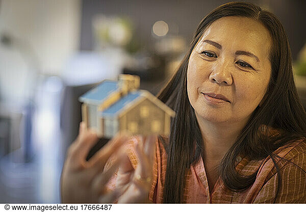 Female architect looking at tiny house model