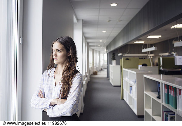 Female architect looking through window