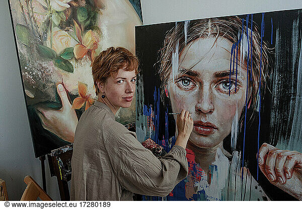 Female artist painting on canvas in studio