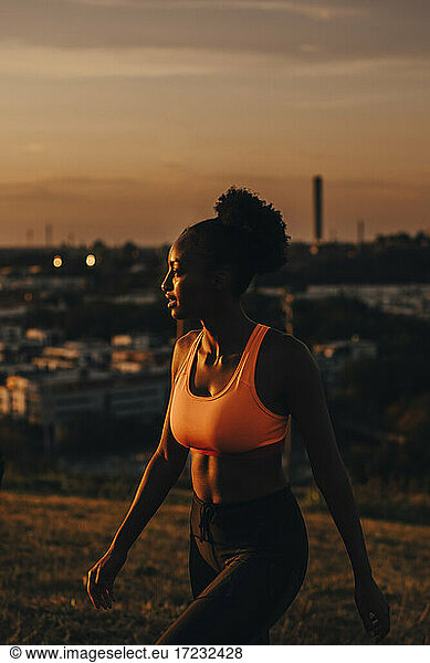 Female athlete looking away during sunset
