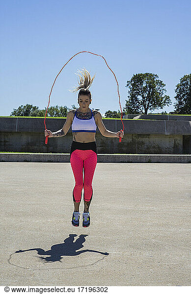 Female athlete skipping rope while working out