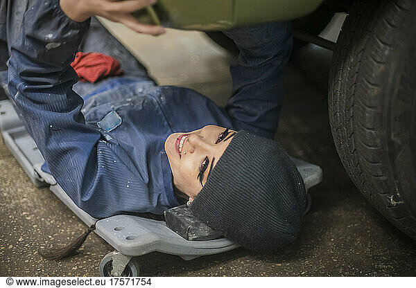 Female Auto worker working on chassis of car
