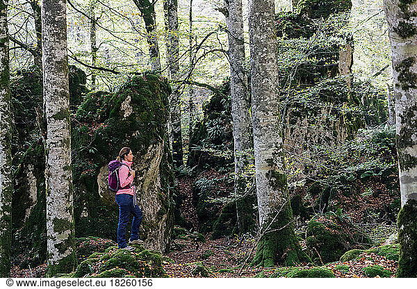 Female backpacker admiring the autumn forest.