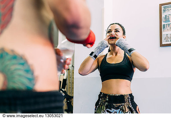 Female boxer putting on mouth guard
