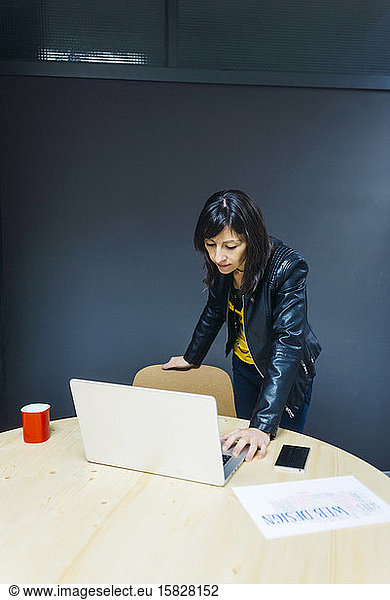 Female business executive looking at laptop in office