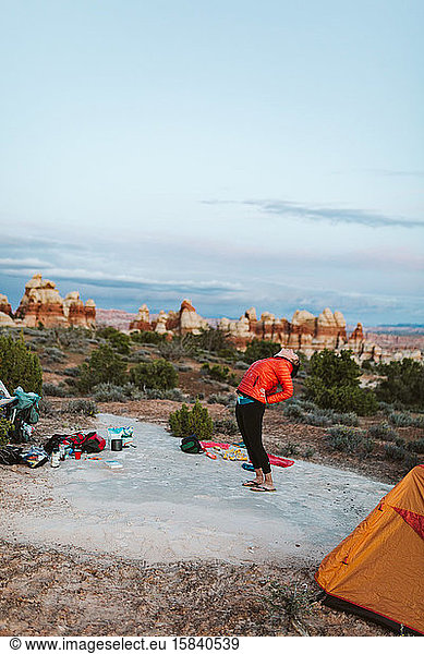 female camper back bending before bedtime in the utah desert