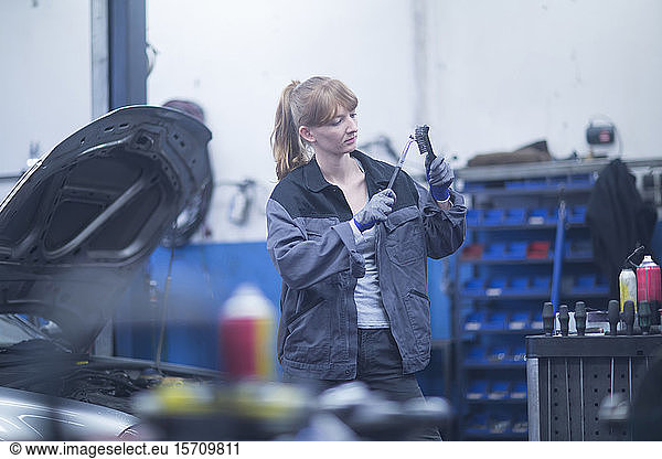 Female car mechanic working in repair garage