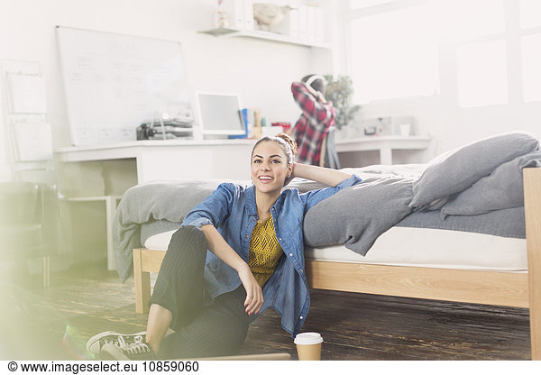 Female college student relaxing on bedroom floor
