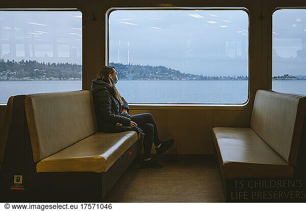 Female commuter sitting on a ferry boat with a view of puget sound